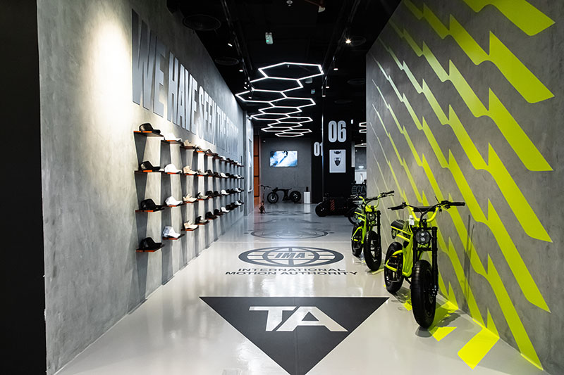 TheArsenale: entrada a la tienda con zapatillas y motos eléctricas