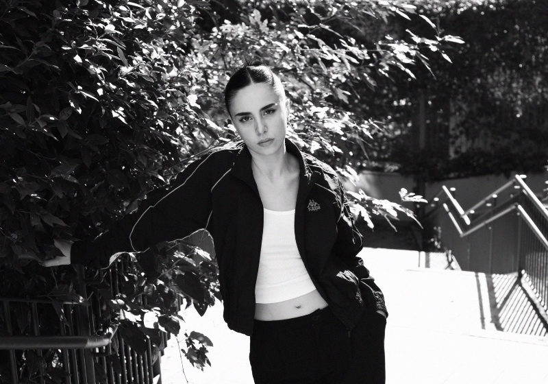 Leire Aguilar apoyada en una barandilla con un look deportivo