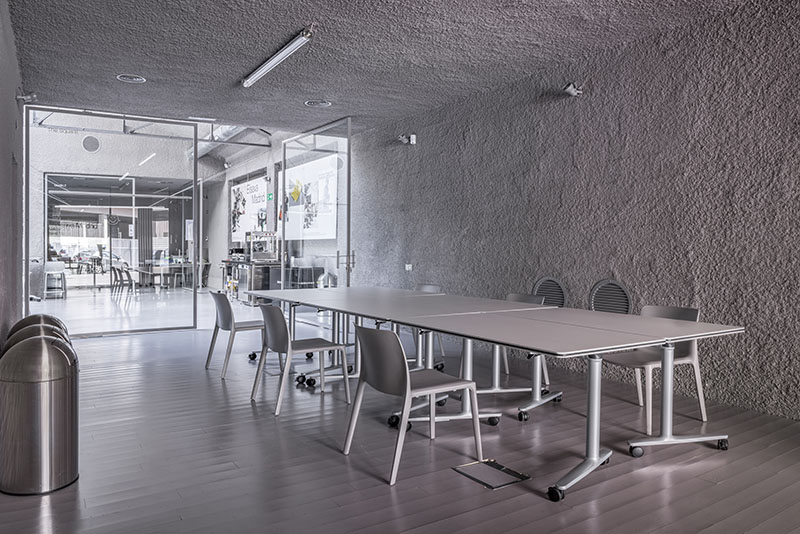 Actiu Elisava Madrid: espacio diáfano de Elisava Madrid con mobiliario de Actiu distribuido y una pantalla para mostrar elementos multimedia.