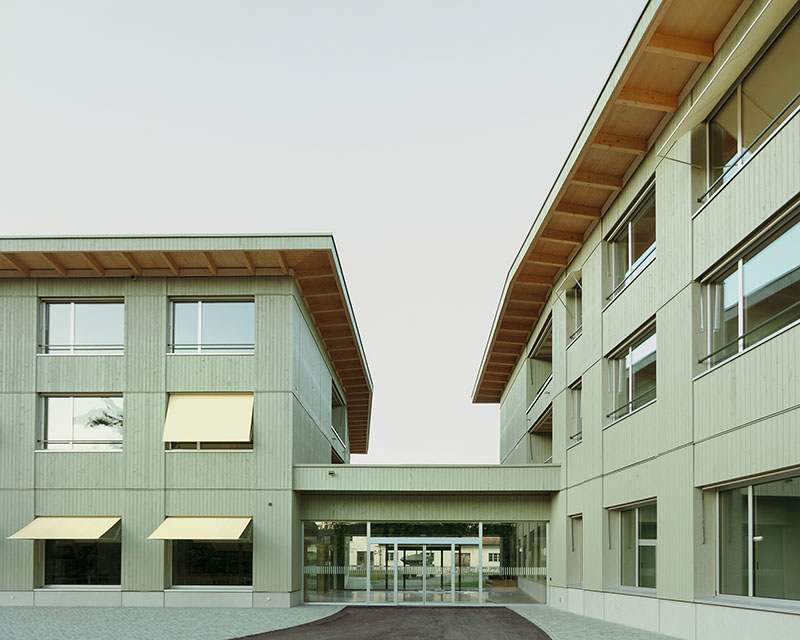 Borna-Park, Malte Kloes Architekten: pasillo interior en el edificio residencial con luz natural entrando desde el ventanal circular