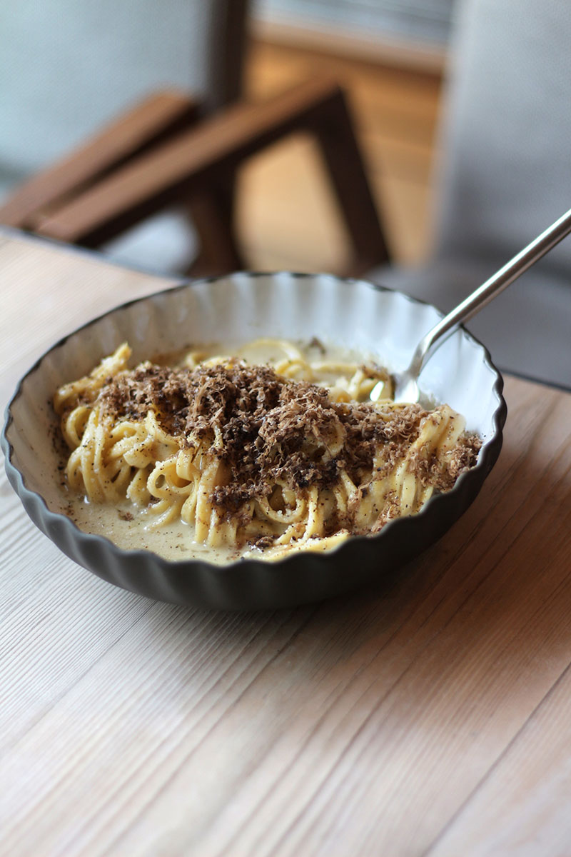 Bosco de Lobos sirve esta pasta con salsa cremosa y trufa rallada sobre una mesa de madera, en pleno ambiente de otoño en el restaurante