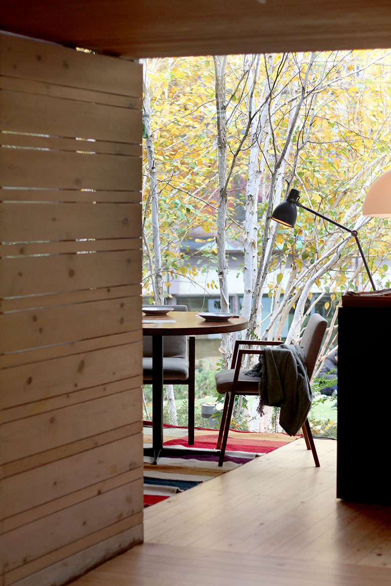 Una mesa junto al ventanal, rodeada de árboles dorados, captura el espíritu de otoño en el restaurante Bosco de Lobos