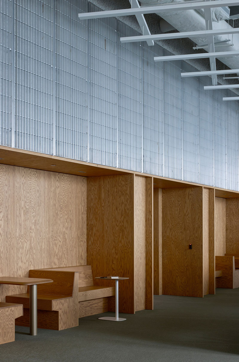 Un corredor del Centre Sanaaq incorpora bancos de madera integrados y paredes revestidas del mismo material