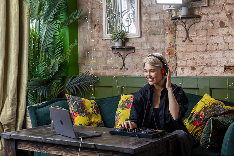 Usuaria mezclando con la controladora DJ de AlphaTheta conectada a un portátil.