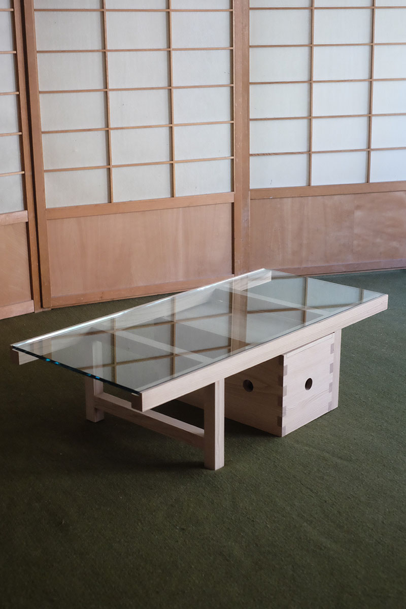 Mesa de cristal en Core de Karimoku con estructura de madera ensamblada