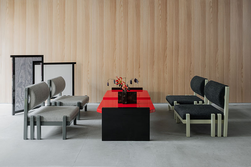 Área de asientos en Core de Karimoku con mesas lacadas en rojo y sillas tapizadas