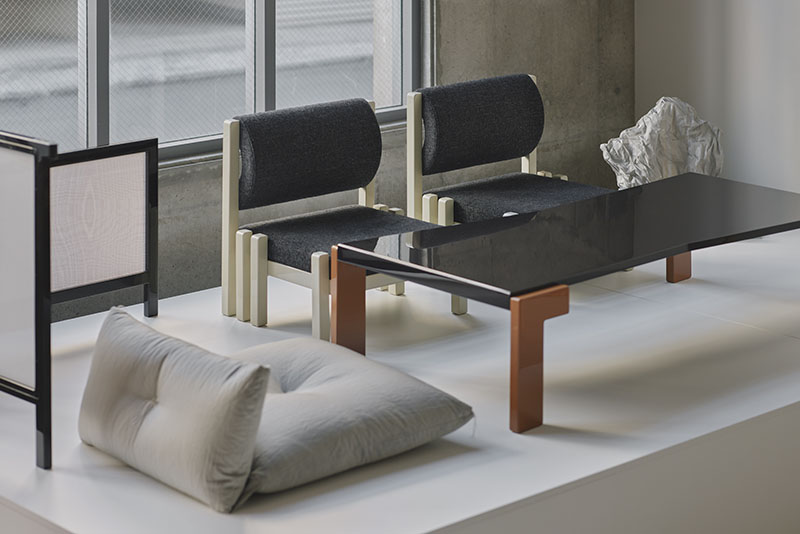 Conjunto de muebles en Core de Karimoku con mesa negra y sillas tapizadas en gris