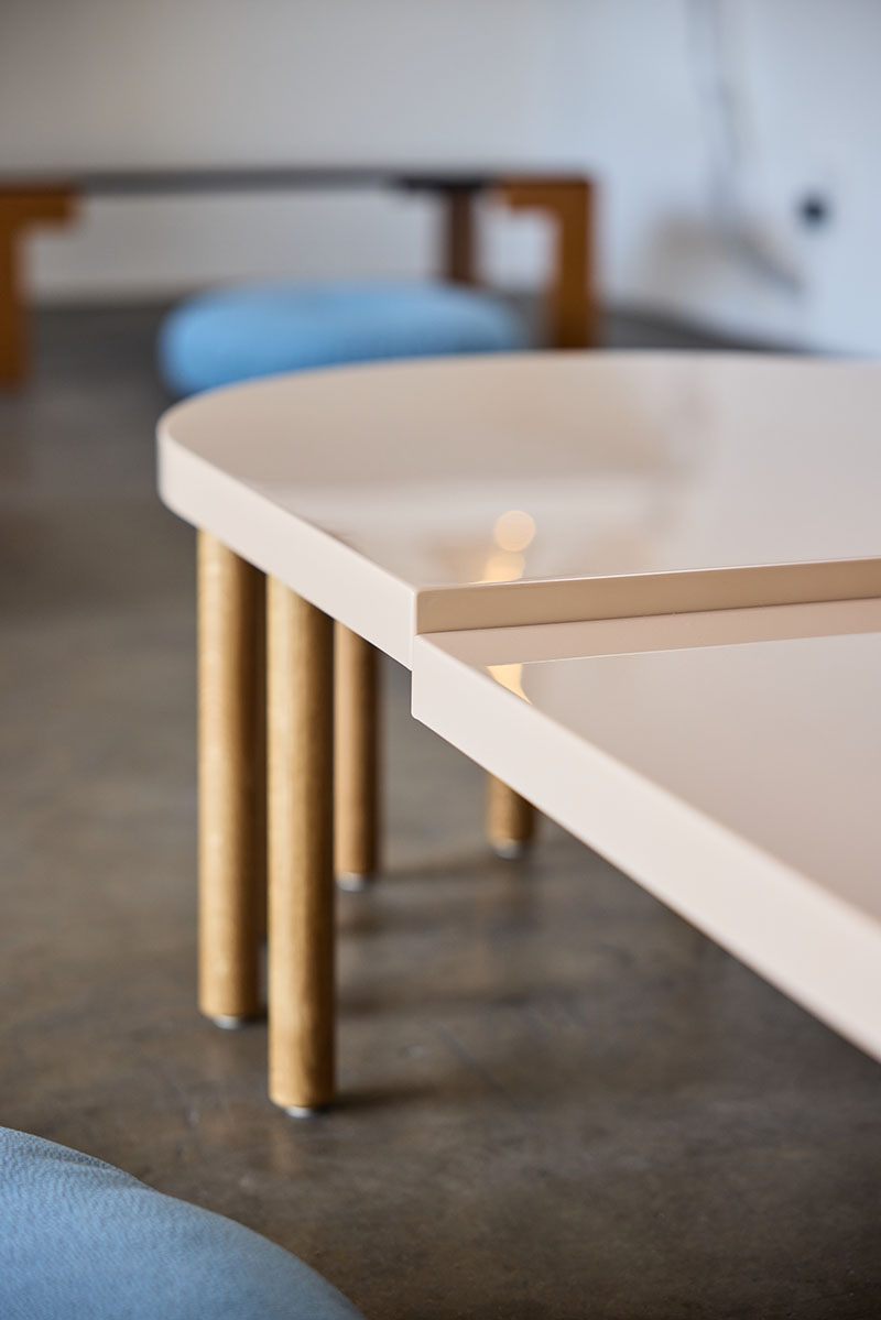 Detalle de mesa en Core de Karimoku con tablero claro y patas cilíndricas de madera