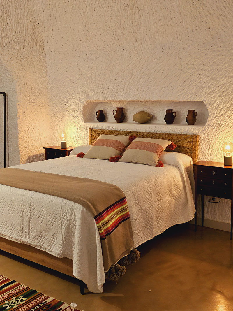 Dormitorio principal de Cuevas de Kabila en Granada con iluminación cálida