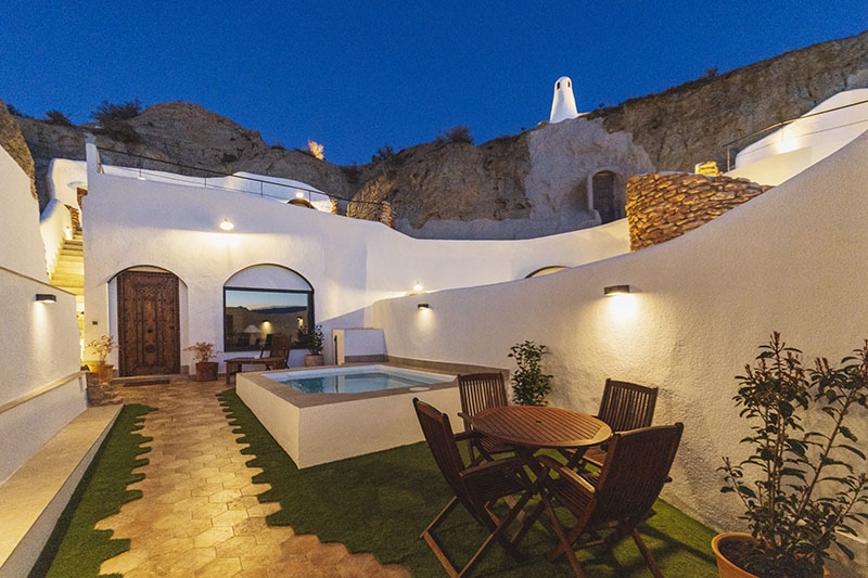 Terraza exterior de Cuevas de Kabila en Granada con piscina y zona de comedor al aire libre