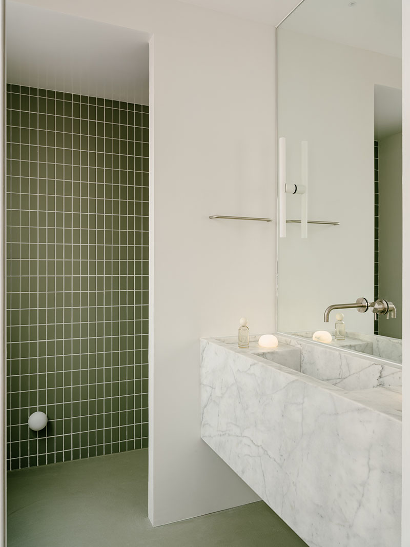 D Iriondo Studio muestra un baño con lavabo de mármol de Carrara y ducha revestida con baldosa verde mate