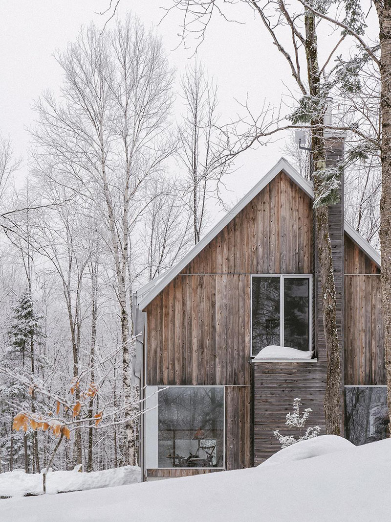 EM architecture captura el frente a dos aguas con revestimiento de madera y ventanas amplias