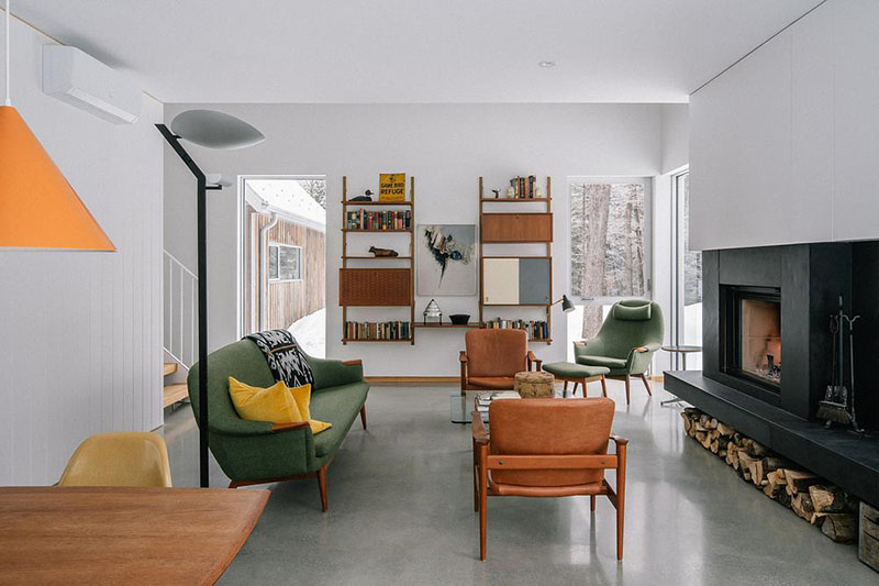 EM architecture ofrece la vista del salón con mobiliario mid-century y chimenea central