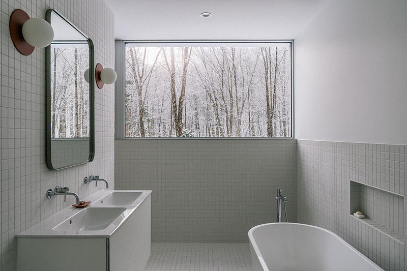 EM architecture presenta el baño principal con un ventanal amplio orientado al bosque