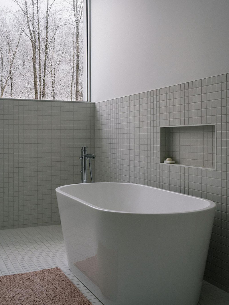 EM architecture destaca la bañera exenta junto al paño de azulejo y la ventana superior