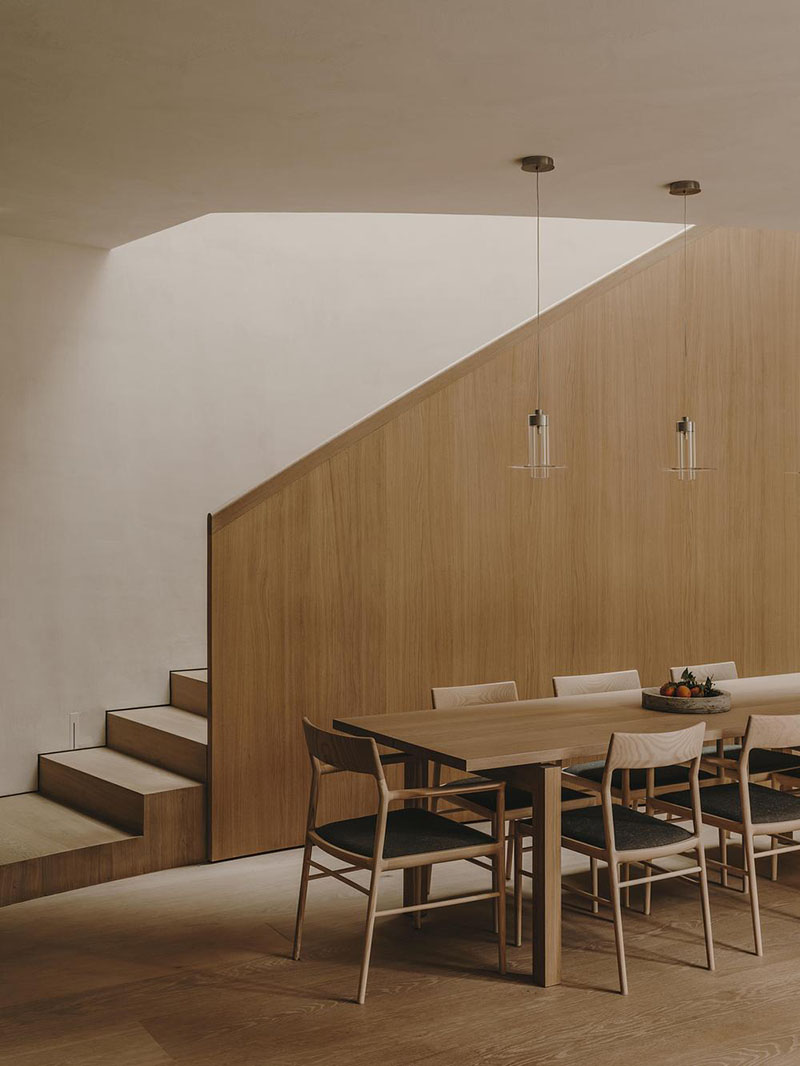 Interiorismo de la Casa en París por Holzrausch que incluye la escalera y el comedor en un volumen de roble