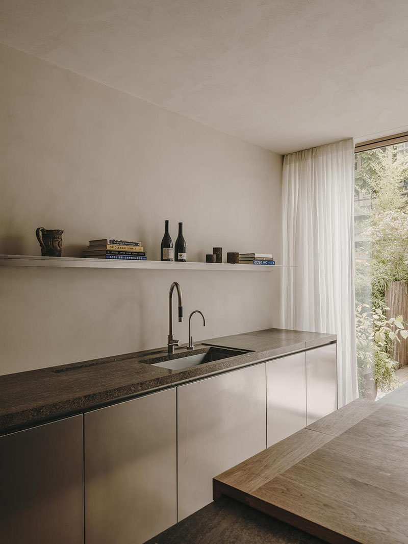 Interiorismo de la Casa en París por Holzrausch que presenta la encimera continua de acero y piedra en la cocina