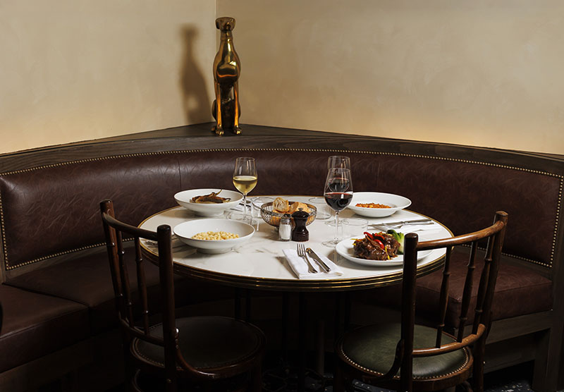 Una mesa preparada del restaurante L'Arrêt en París muestra varios platos y copas