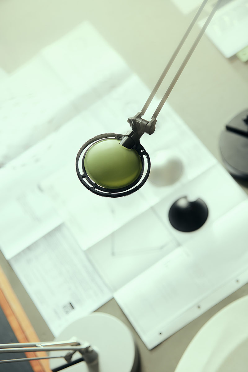 Luceplan: foto de luna de las piezas de una lámpara de mesa sobre las instrucciones e iluminadas por otra lámpara de mesa.