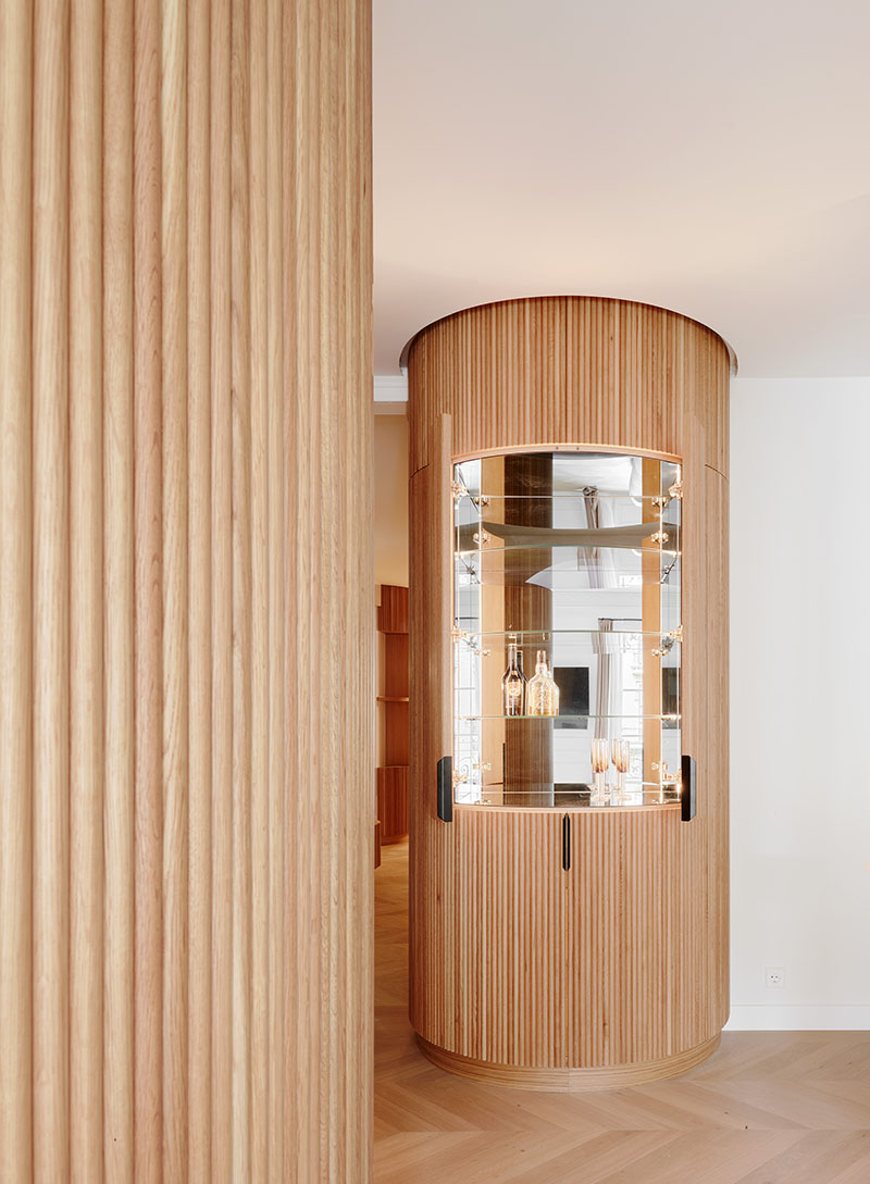 Miel Arquitectos integran en Long Flat un mueble bar cilíndrico con frente de espejos