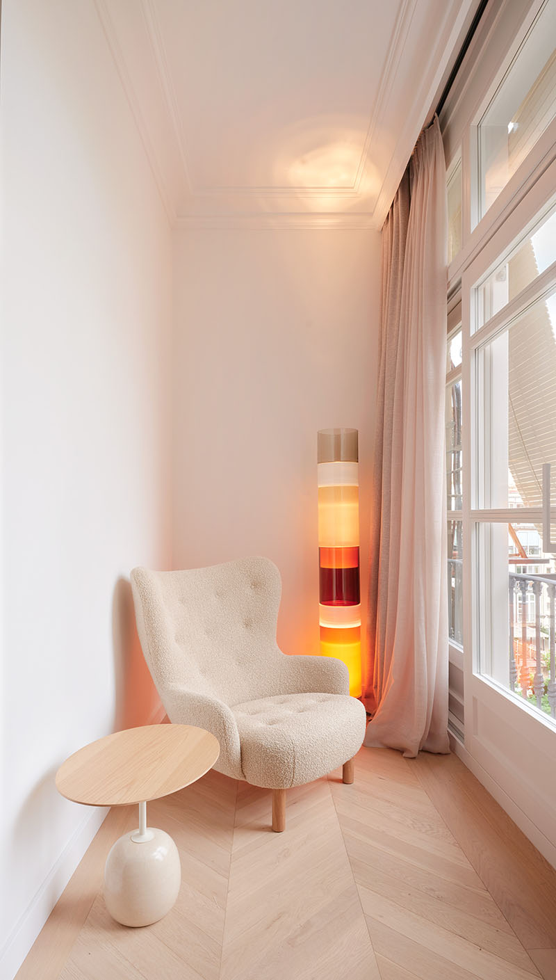 Miel Arquitectos disponen en Long Flat un rincón de lectura junto a la ventana con butaca y lámpara vertical