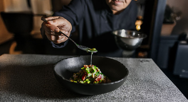 Un cocinero sirve un plato en preparación en El Bajío Madrid