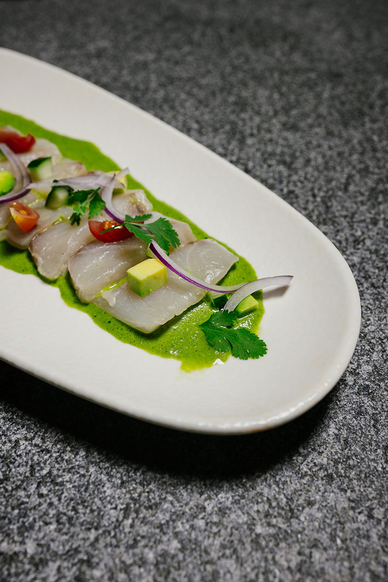 Aguachile verde emplatado sobre bandeja alargada en El Bajío Madrid