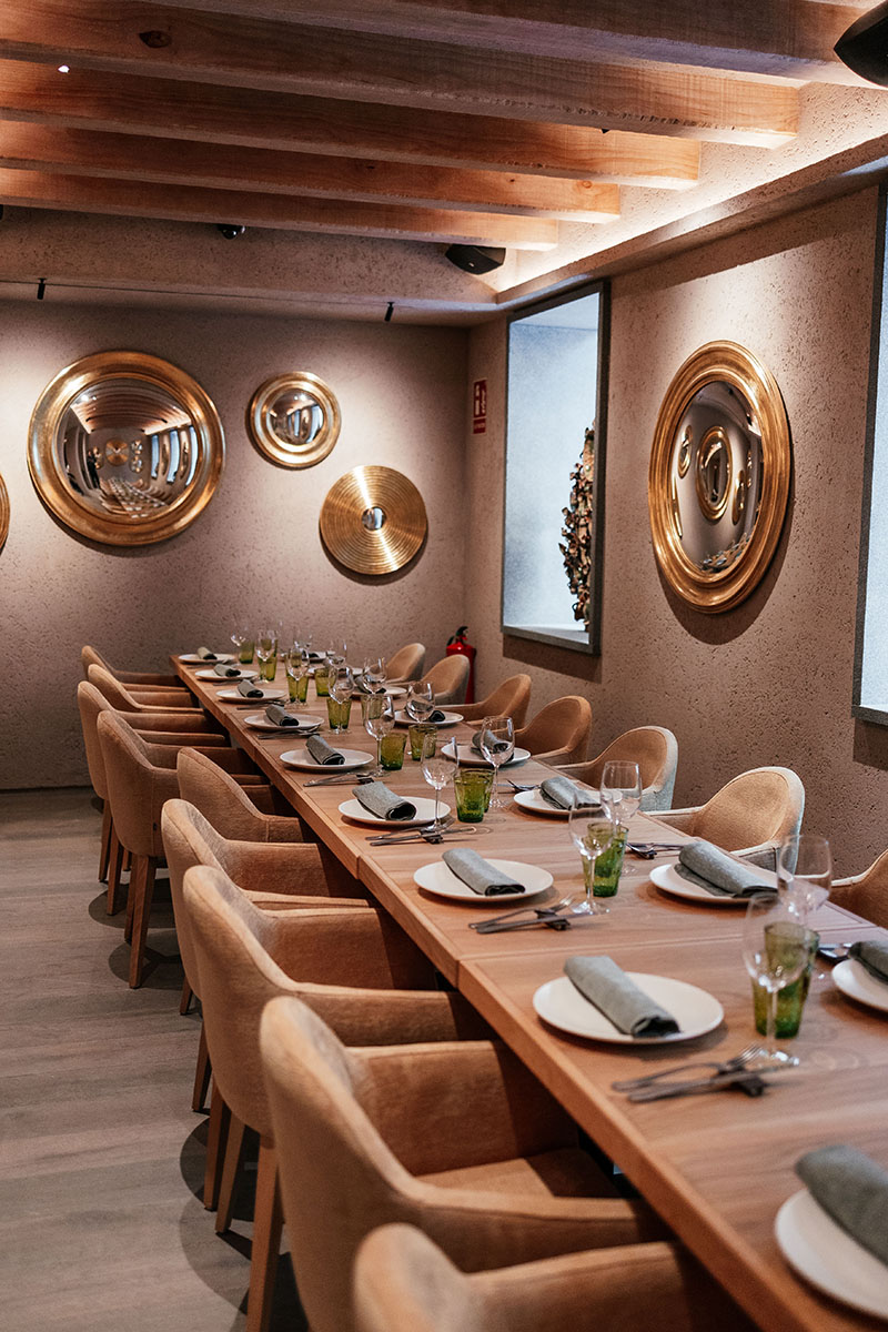 Sala de comedor con mesa larga y decoración dorada en El Bajío Madrid