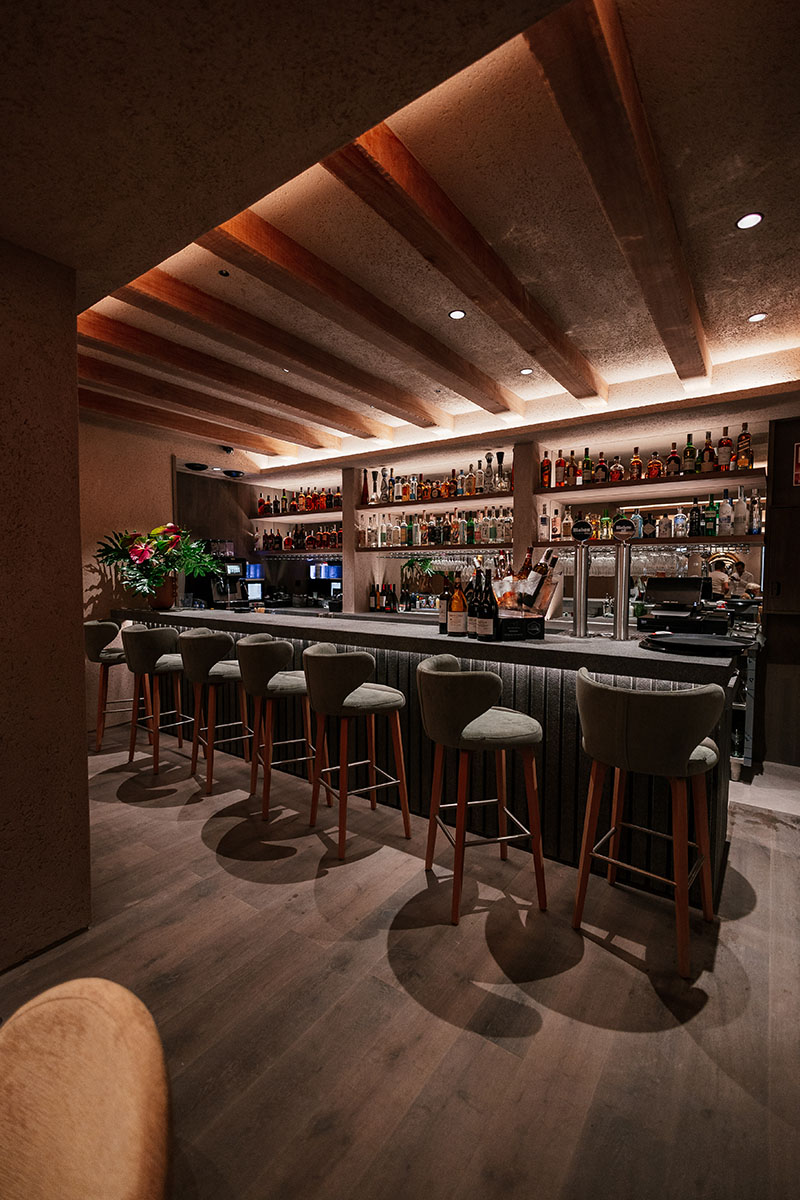 Barra de coctelería con estantería de botellas en El Bajío Madrid