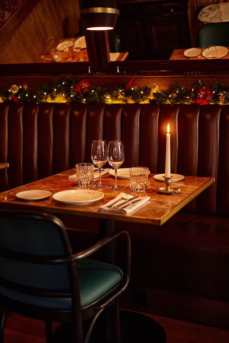 Restaurante La Dama y menús de Navidad y Sant Esteve 2025: mesa preparada con vajilla, copas y vela en el interior del local decorado para las fiestas