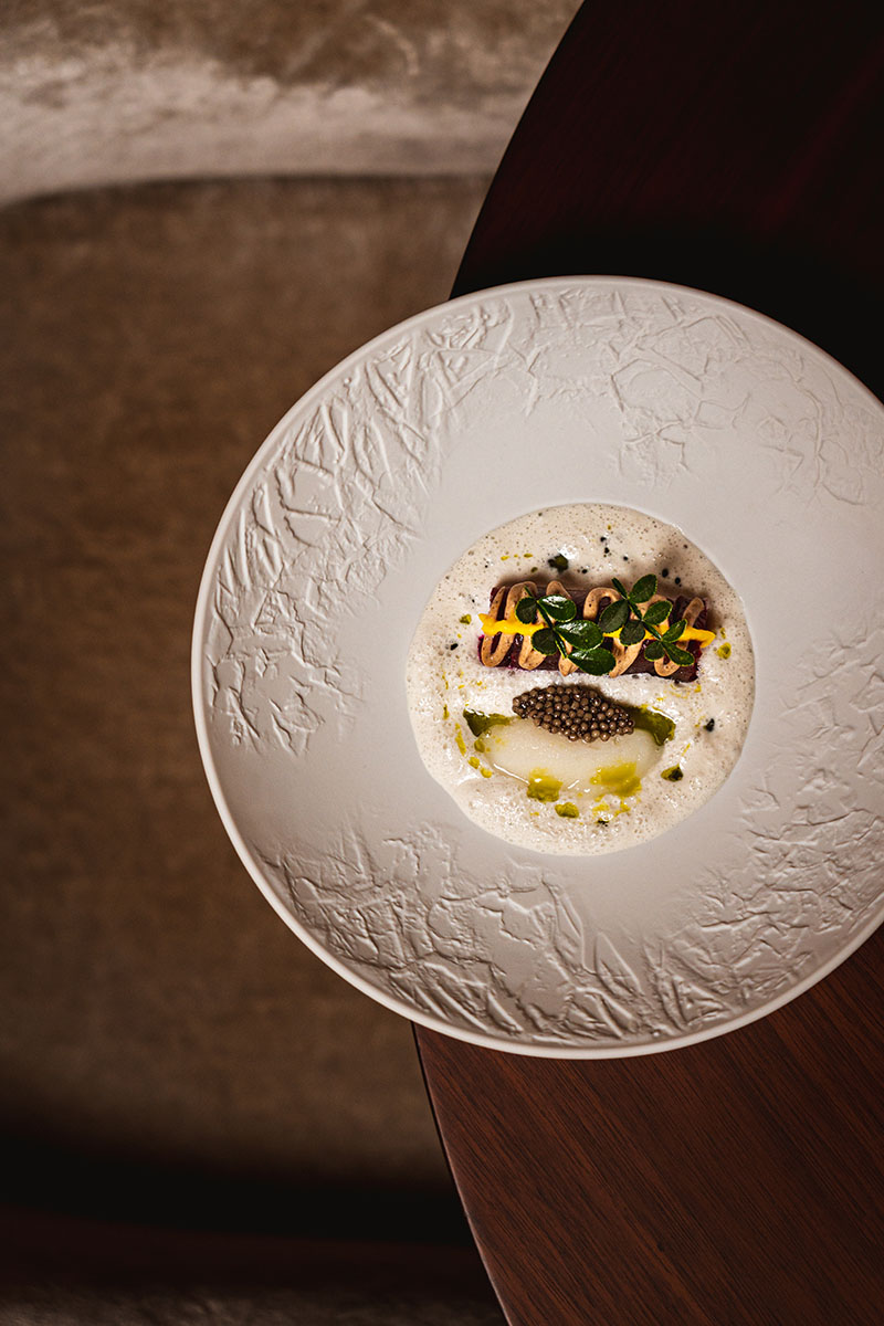 Plato del Restaurante Suba en Lisboa con atún, caviar y espuma en vajilla blanca