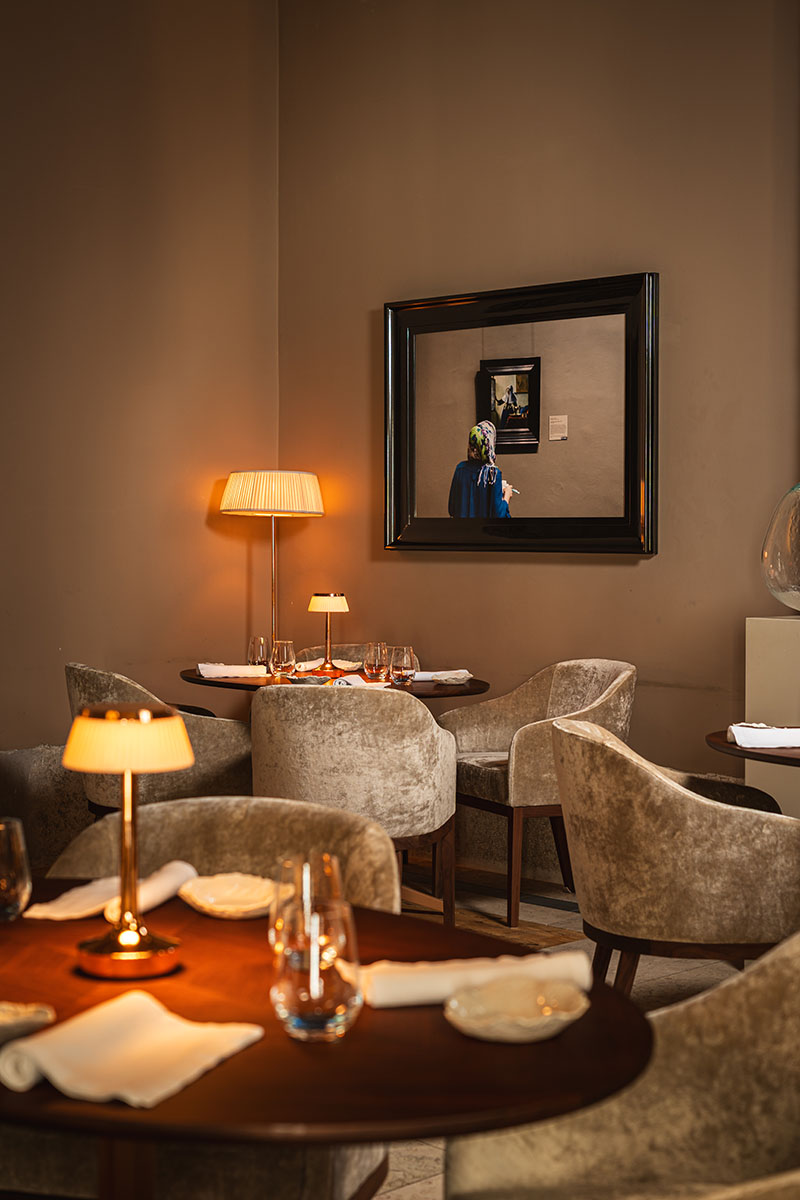 Sala del Restaurante Suba en Lisboa con mesas redondas, lámparas bajas y butacas tapizadas