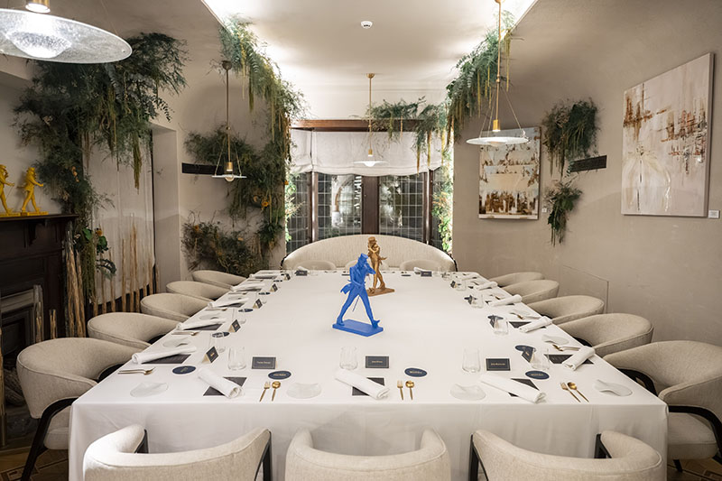 Sala principal de The Blue Odyssey, de Johnie Walker Blue, con una mesa larga montada para servicio en Mom Culinary Institute