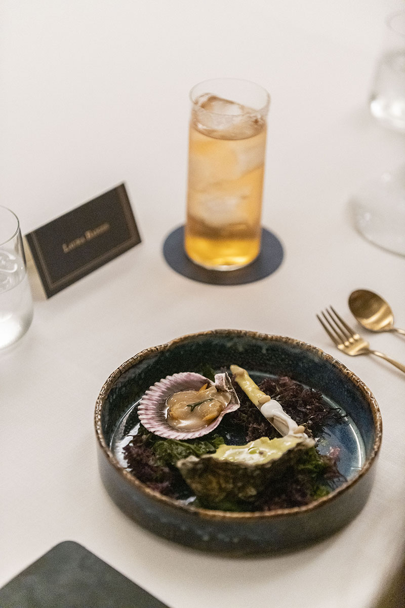 Plato de marisco con un cóctel alto servido en The Blue Odyssey de Johnie Walker Blue