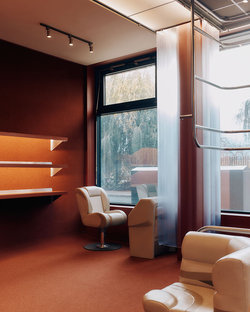 Thiss Studio interiorismo tienda KK London: espacio con pasamanos de barco y sofás de cuero blanco