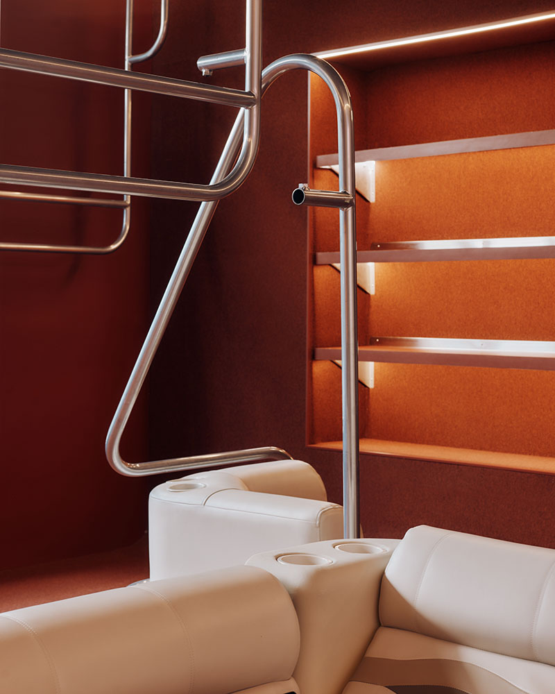 Thiss Studio interiorismo tienda KK London: espacio con pasamanos de barco y sofás de cuero blanco