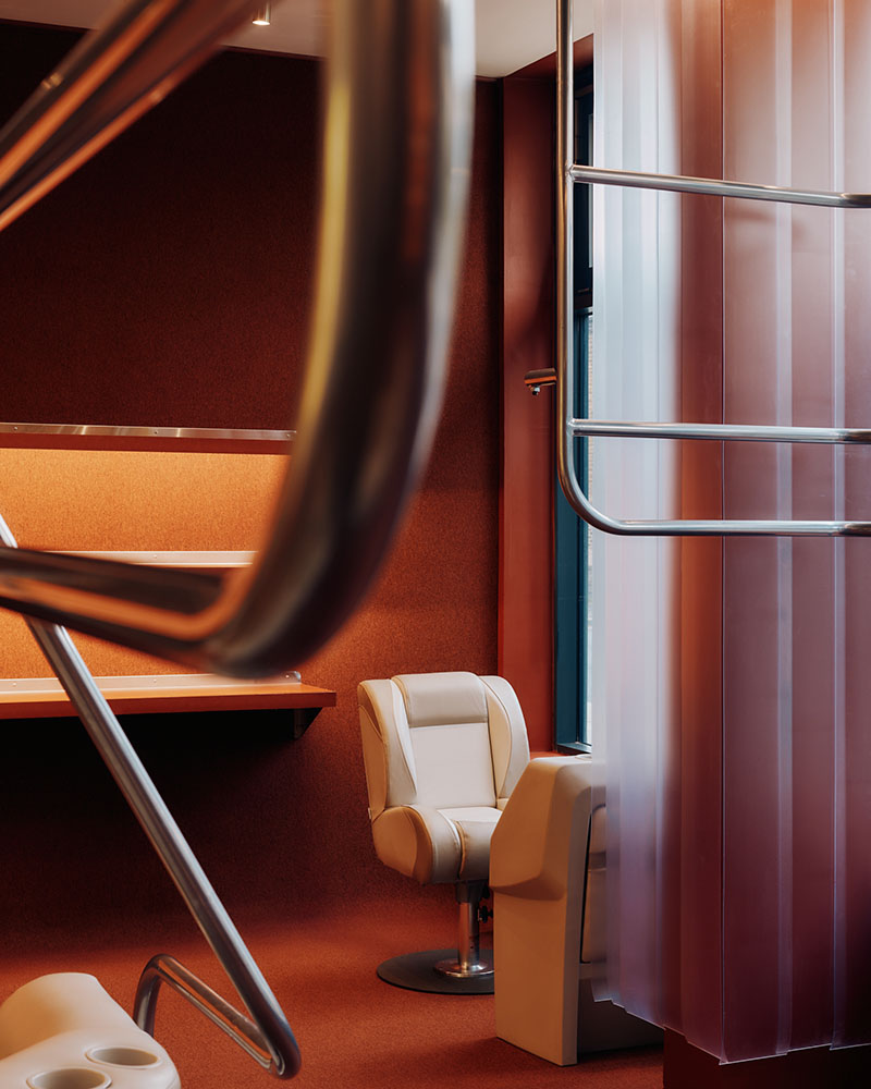 Thiss Studio interiorismo tienda KK London: espacio con pasamanos de barco y sofás de cuero blanco