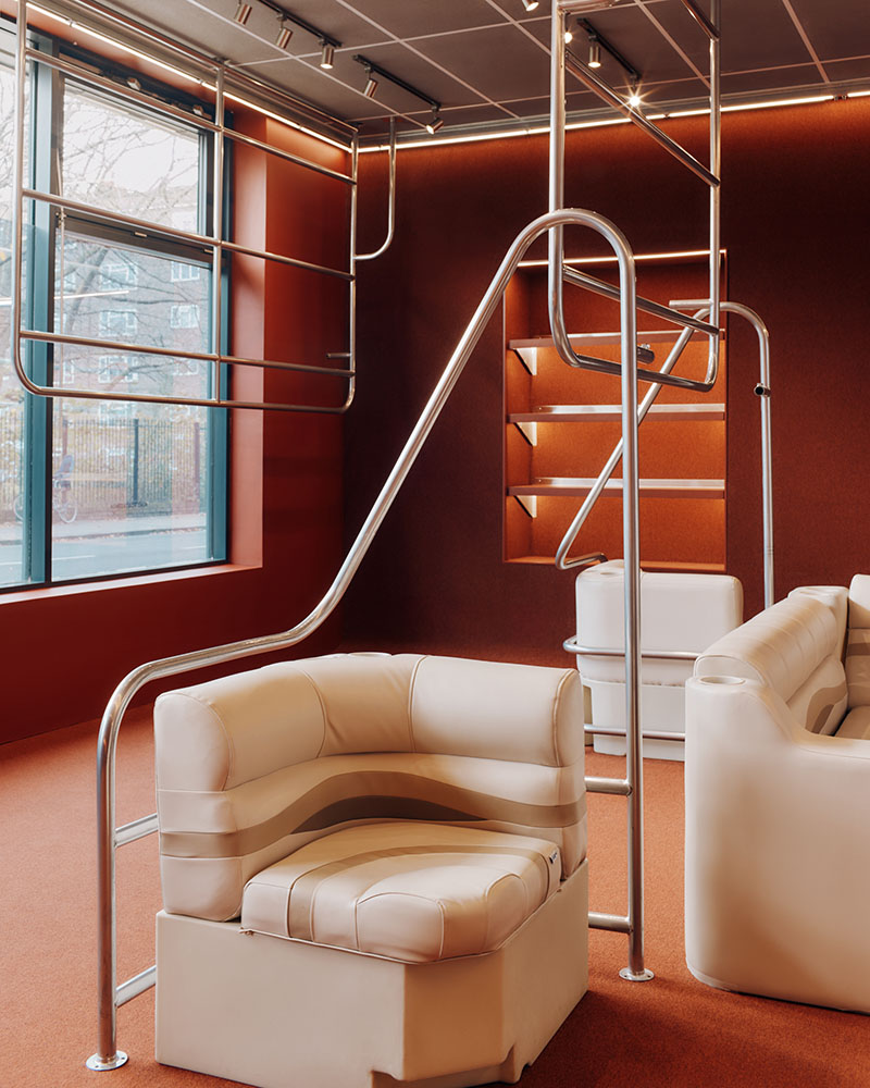 Thiss Studio interiorismo tienda KK London: espacio con pasamanos de barco y sofás de cuero blanco