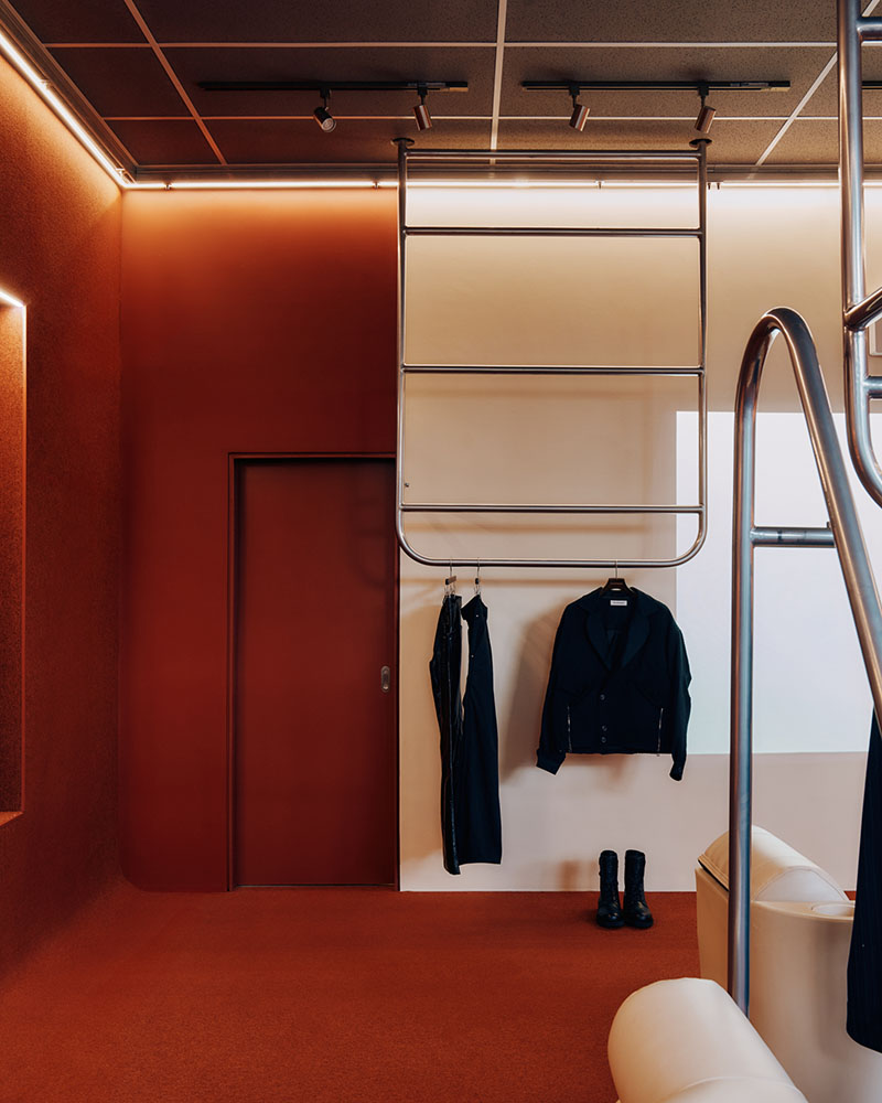 Thiss Studio interiorismo tienda KK London: espacio con pasamanos de barco y sofás de cuero blanco