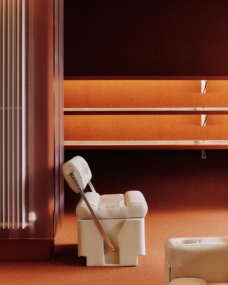 Thiss Studio interiorismo tienda KK London: espacio con pasamanos de barco y sofás de cuero blanco