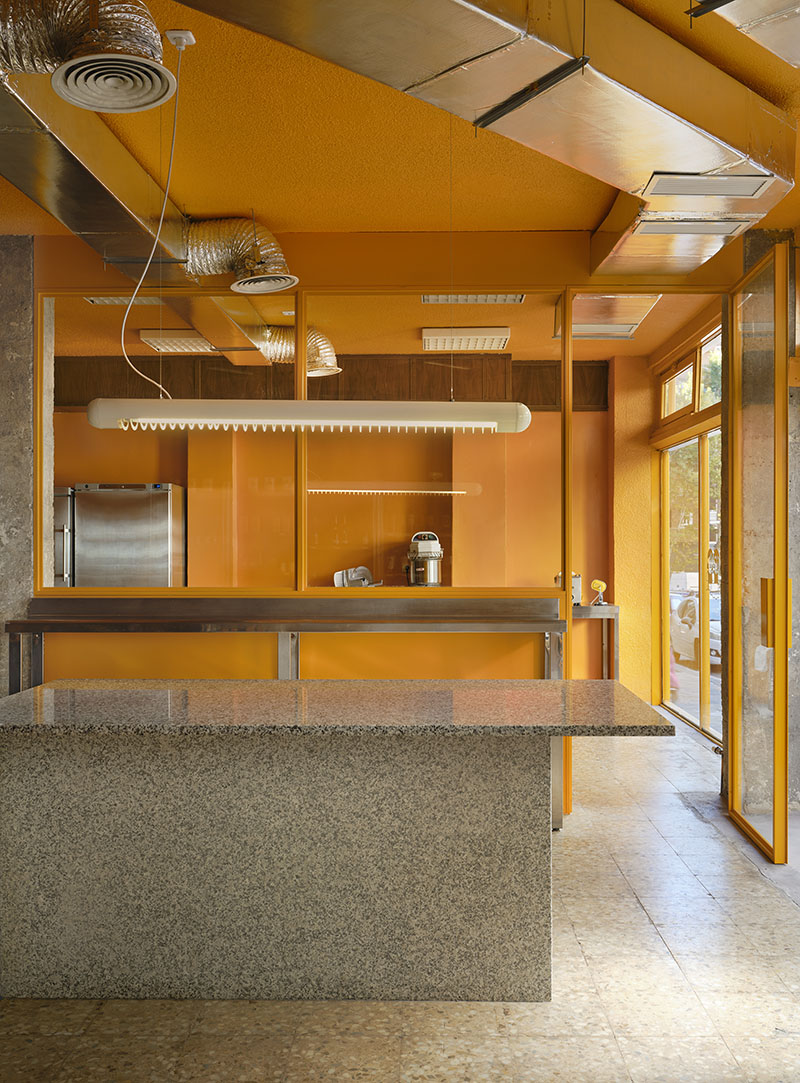 Mesa central de Central de Pastas creada por Codoo Studio frente al cerramiento acristalado