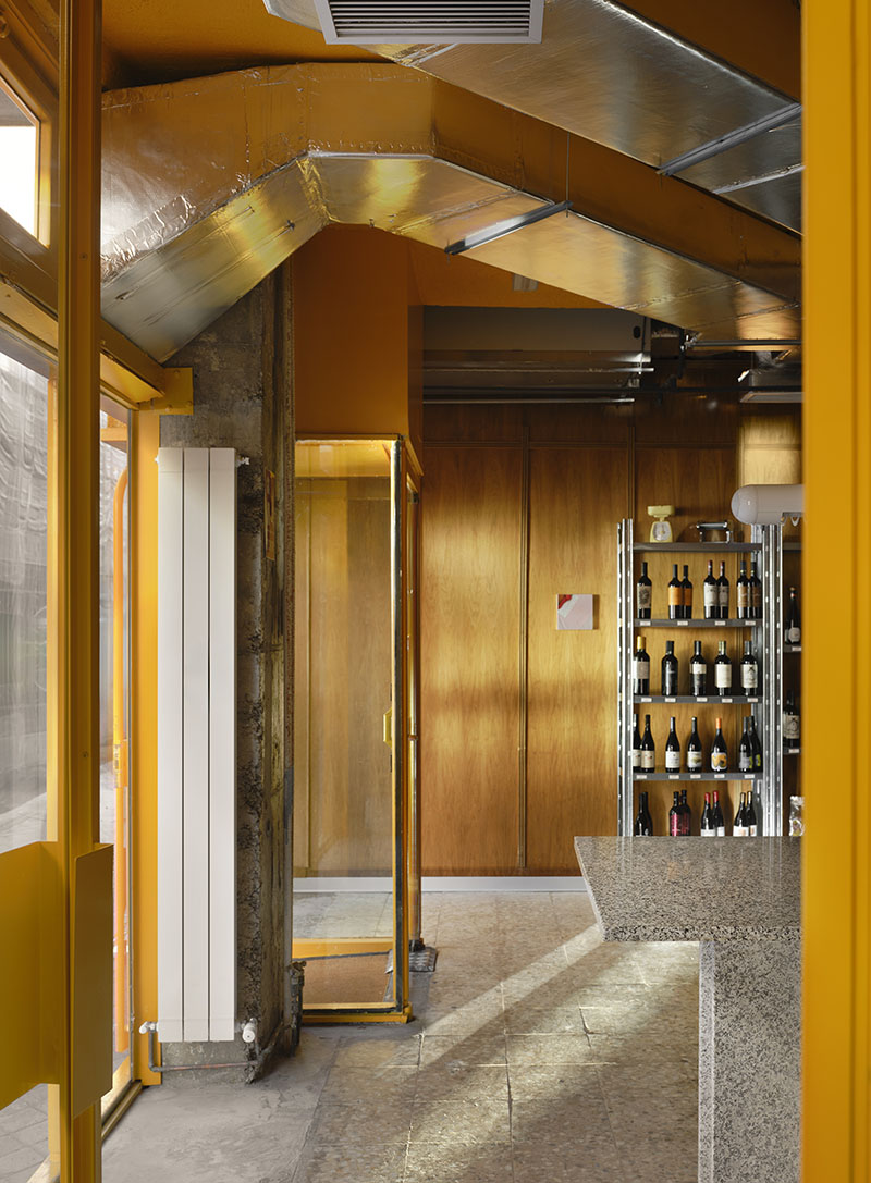 Transición entre fachada e interior de Central de Pastas resuelta por Codoo Studio con carpintería amarilla