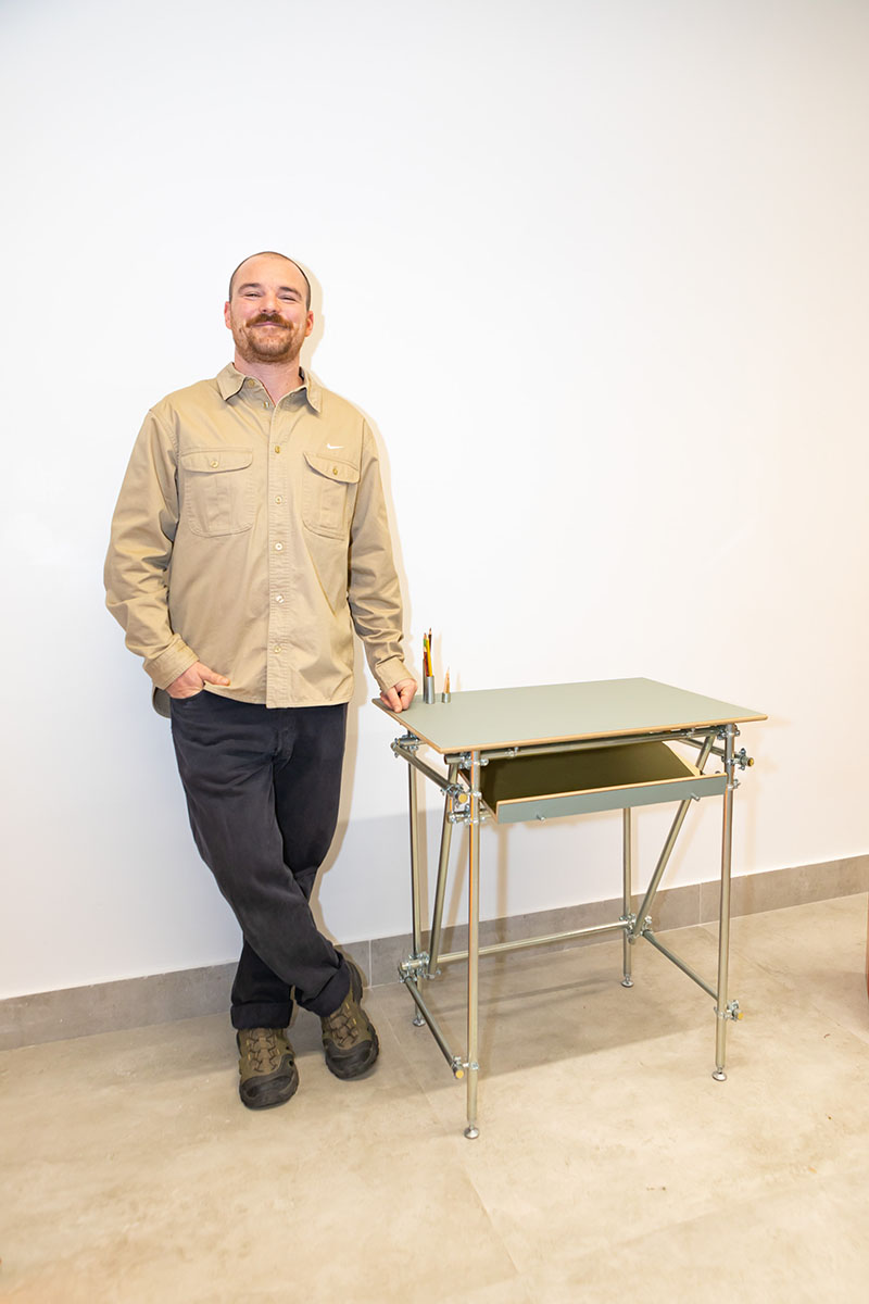 Ase Torralba posando junto a su mesa realizada con superficie de Formica para el proyecto de TetuánCrea