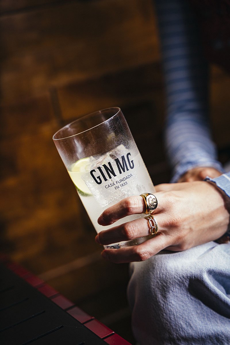 Persona disfrutando de GIN MG en una reunión organizada por el anfitrión