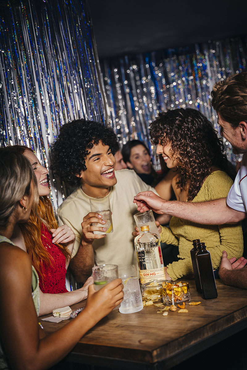 Personas disfrutando de GIN MG en una reunión organizada por el anfitrión