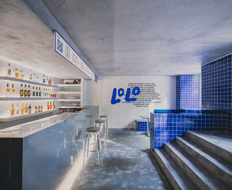 Lolo Taco Bar y Carne muestran una barra metálica con estanterías iluminadas y un muro con la identidad gráfica del local