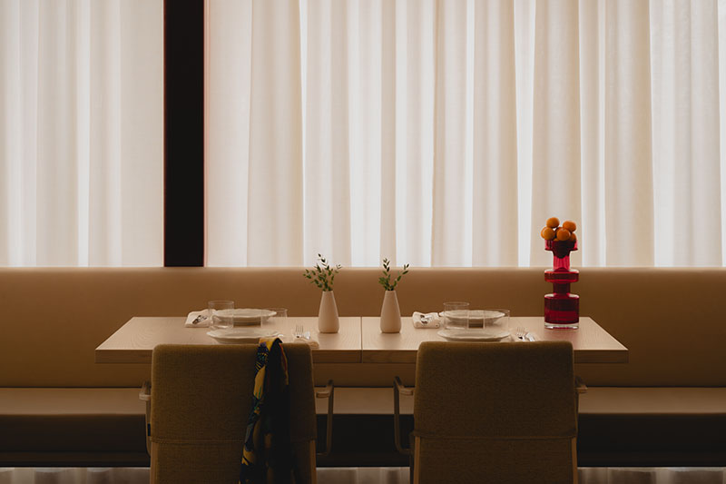 Ste Marie presenta en Olia una mesa doble con vajilla mínima y cortinas filtrando luz