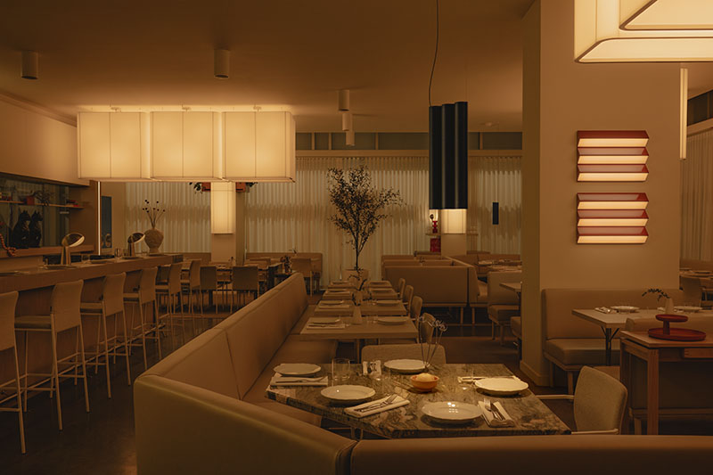 Ste Marie ordena en Mimi un comedor amplio con mesas bajas y lámparas de gran formato