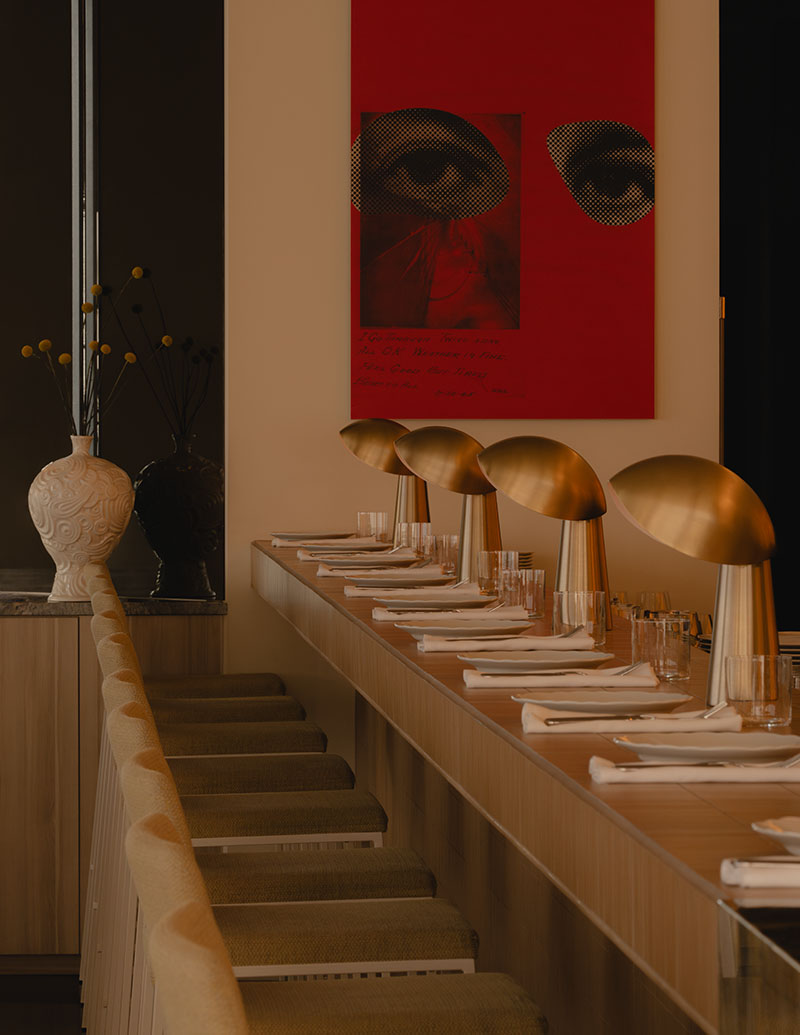 Ste Marie alinea en Mimi una barra con lámparas doradas y una obra roja al fondo